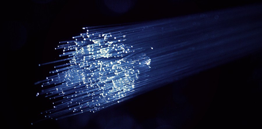 Illuminated fiber optic strands against a dark background, representing Parsian Holdings' technology and digital products